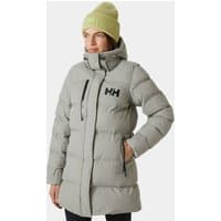 Grey Helly Hansen women's puffy parka with hood, front zipper, and logo on chest, worn by model with green beanie.