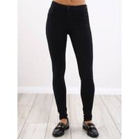 Black skinny fit jeans with a mid-rise waist, button closure, and sleek design, worn with black loafers.