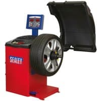 Red Sealey WB10 semi-automatic wheel balancer with digital display and black protective cover, holding a car wheel.