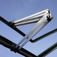 Silver Palram Canopia Greenhouse Auto Vent Arm with dual hydraulic pistons and metal frame against blue sky.