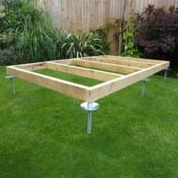 QuickJACK Adjustable Shed Base System with wooden frame and metal supports on grass.