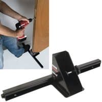 Black Trend Universal Door Clamp & Stand with adjustable arms and sturdy base, shown in use on a wooden door.