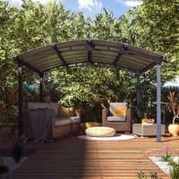 Arched metal-framed garden gazebo with polycarbonate roof panels, set on a wooden deck surrounded by greenery.