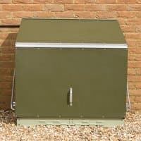 Green metal garden storage unit with sloped roof, front handle, and secure base against a brick wall.