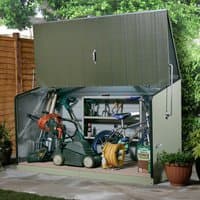 Green metal garden storage unit with hinged roof, open front, and shelves, storing tools and a lawnmower.