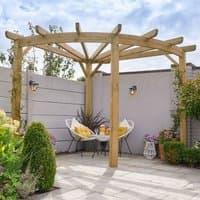 Wooden garden corner pergola with radial beams, natural finish, set in a landscaped patio with plants and chairs.