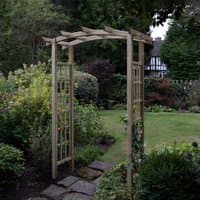 Wooden garden pergola arch with dome top, lattice sides, and natural finish, set in a lush garden setting.