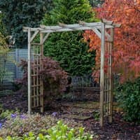 Wooden garden pergola arch with flat top, lattice sides, and natural finish, set in a lush garden setting.