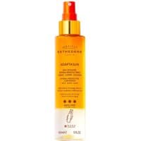 Orange and white Esthederm spray bottle with gold cap, labeled "Eau Solaire Hydra-Protectrice" for face and body.