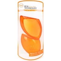 Orange Real Techniques makeup sponge with matching travel box in clear cylindrical packaging.