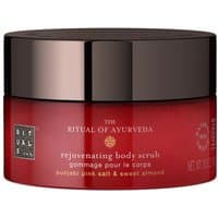 Red jar of Rituals The Ritual Of Ayurveda body scrub with dark brown lid, labeled with gold and white text.