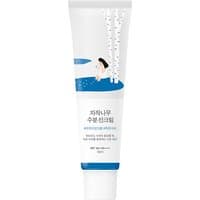 White tube of Round Lab Birch Juice Moisturizing Sunscreen SPF 50, featuring birch tree and water illustration.