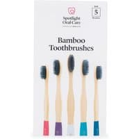 Bamboo toothbrush set of five with colored bases and black bristles, packaged in a white Spotlight Oral Care box.