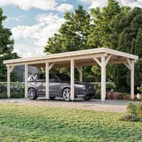 Wooden carport with a flat roof, open sides, and sturdy beams, housing a car, set in a grassy area with trees.