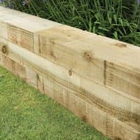 Forest 4ft pressure treated landscaping sleeper pack, light brown wood with visible grain and knots, stacked on grass.