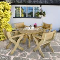 Circular wooden garden table with four matching chairs, natural finish, set on a stone patio near a cottage.