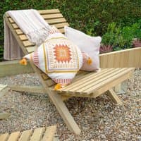 Forest slatted wooden garden chair with angled backrest, natural finish, draped blanket, and decorative cushions.