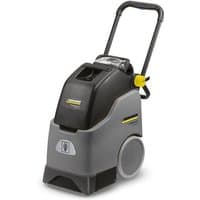 Karcher BRC 30/15 C upright carpet cleaner, gray and black with yellow accents, large rear wheels, and ergonomic handle.