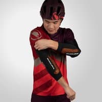 Black MT500 D3O® Ghost Elbow Pads with sleek design, worn by a cyclist in a red jersey and helmet.