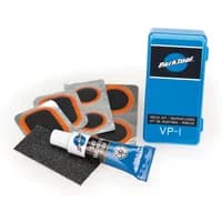 Park Tool VP-1 Vulcanizing Patch Kit with blue case, adhesive tube, sandpaper, and multiple black and orange patches.