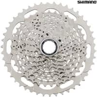 Silver Shimano Deore 10-speed cassette with 11-46T range, intricate gear teeth design, and central mounting hole.