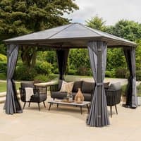 Grey polycarbonate garden gazebo with a peaked roof, four curtains, and metal frame, set on a patio with outdoor furniture.