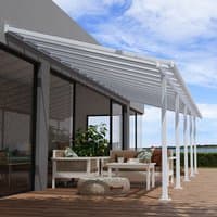 White Palram Canopia Olympia patio cover with clear panels, attached to a house, over a wooden deck with outdoor furniture.