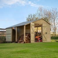 Wooden apex shed with double doors, logstore, tongue and groove panels, pressure-treated timber, set on grass.