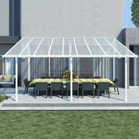 White Palram Canopia Sierra patio cover with clear roof panels over outdoor dining set, attached to a modern house.