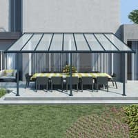 Grey Palram Canopia Sierra patio cover with clear roof panels and sturdy frame over outdoor dining area.