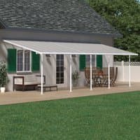 White Palram Canopia Sierra patio cover with clear panels and white frame attached to house over patio area.