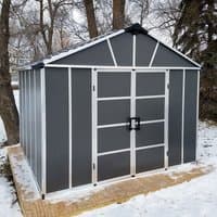 Dark grey plastic shed with skylight, white trim, double doors, and sloped roof, set on a wooden platform.