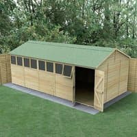 Wooden double door shed with green roof, tongue and groove panels, reverse apex design, surrounded by trees.