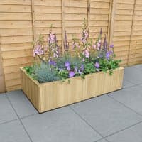 Rectangular wooden planter with shiplap design, filled with purple and green plants, set on a gray patio.