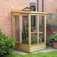 Wooden lean-to greenhouse with glazed back, clear panels, and sloped roof, attached to a brick wall.
