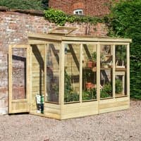 Wooden lean-to greenhouse with clear panels, solid back, and sloped roof, attached to a brick wall.