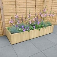 Wooden planter with horizontal shiplap design, filled with pink and purple flowers, against a wooden fence.