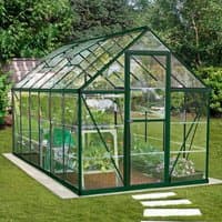 Green polycarbonate greenhouse with a peaked roof, clear panels, and metal frame, featuring a front door and side vents.