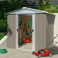 Tall stone grey metal shed with sliding doors, white trim, and gabled roof, surrounded by garden tools and lawnmower.