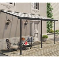 Grey patio cover with clear panels, supported by dark metal frame, attached to a house over wooden deck.