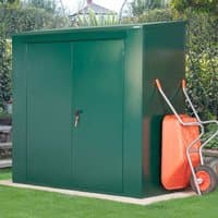 Green metal Asgard shed with double doors, compact size, and adjacent orange wheelbarrow on grass.