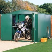 Green metal Asgard motorbike garage with double doors open, revealing a motorbike inside on a gravel base.