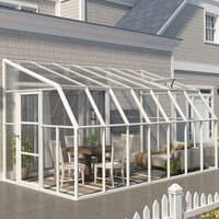 Clear 8x14 Palram Canopia Rion sunroom with white frame, sloped roof, and glass panels attached to a house.