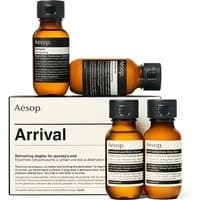 Aesop Arrival Travel Kit with amber bottles and black caps, featuring skincare essentials, packaged in a minimalist box.