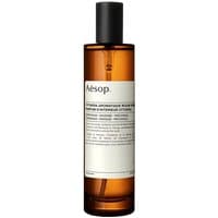 Amber bottle of Aesop Cythera Room Spray with black cap and minimalist white label.