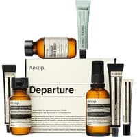 Aesop Departure Travel Kit with amber bottles, cream tubes, and minimalist black-and-white packaging.