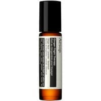 Amber glass roll-on bottle with black cap, labeled "Aesop Ginger Flight Therapy" in white and black text.