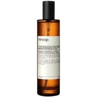Amber bottle of Aesop Olous Citrus Room Spray with black cap and minimalist white label.