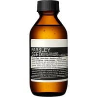 Amber bottle of Aesop Parsley Seed Facial Cleanser, black cap, white label with black text, 100 ml size.