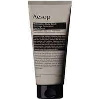 Aesop Redemption Body Scrub 180 ml in beige tube with black cap and text label detailing ingredients and usage.